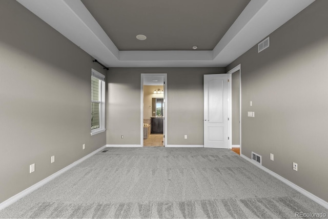17223 W 84th Dr, Arvada, CO 80007 - unfurnished bedroom with carpet, a tray ceiling, baseboards, and ensuite bath
