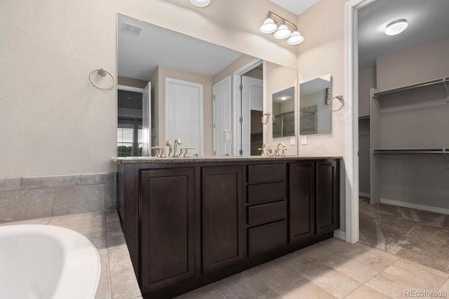 17223 W 84th Dr, Arvada, CO 80007 - bathroom with a walk in closet, double vanity, and a bath