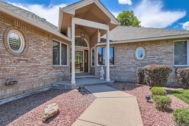 7769 W 70th Dr, Arvada, CO 80004 - doorway to property featuring brick siding and roof with shingles