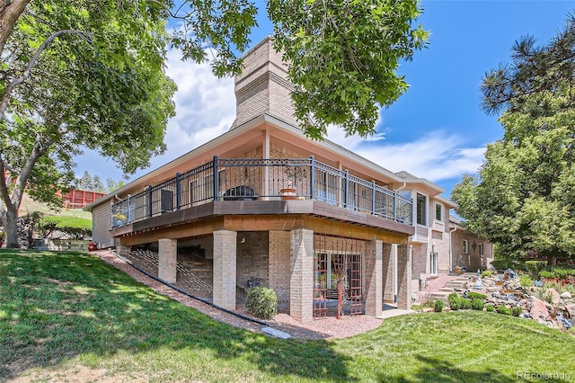 7769 W 70th Dr, Arvada, CO 80004 - rear view of property with a yard, brick siding, a patio, and a chimney