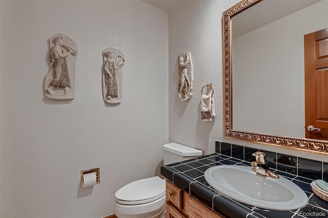 7769 W 70th Dr, Arvada, CO 80004 - half bathroom featuring vanity and tasteful backsplash