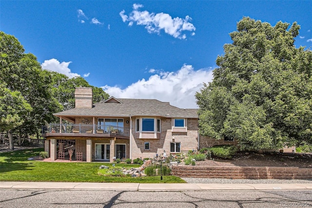 7769 W 70th Dr, Arvada, CO 80004 - back of house with a yard, brick siding, a chimney, and a wooden deck