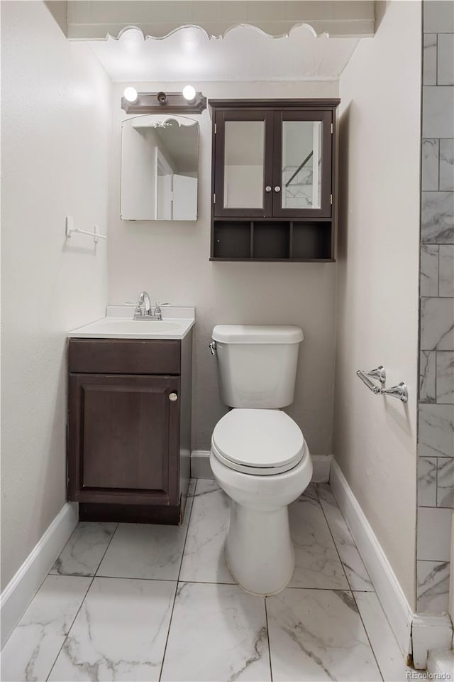 half bath featuring marble finish floors and baseboards