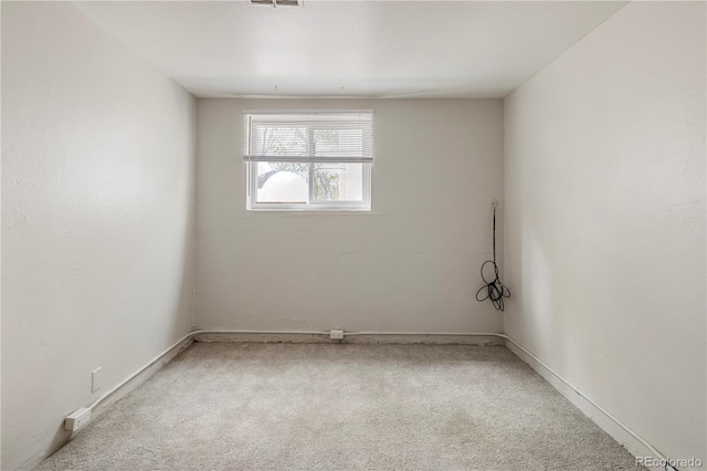 spare room featuring carpet flooring and baseboards