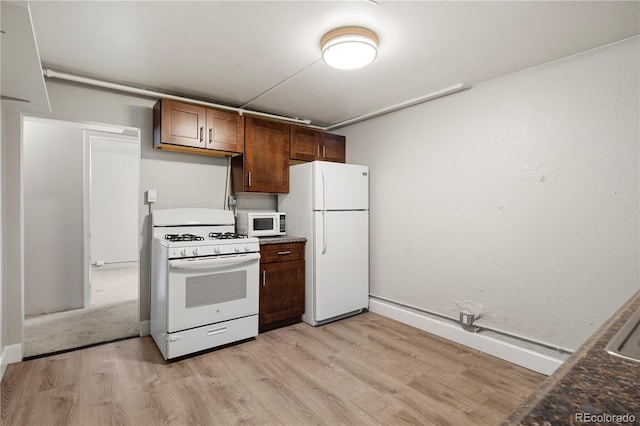 kitchen featuring white appliances, light wood-type flooring, baseboards, and dark countertops