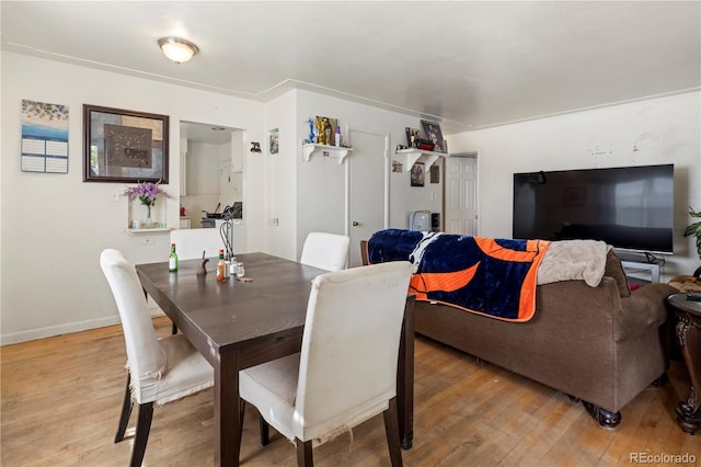 dining area featuring light wood-type flooring and baseboards
