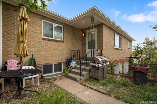 rear view of property with brick siding and fence