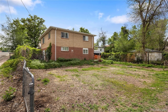 view of home's exterior featuring brick siding and fence