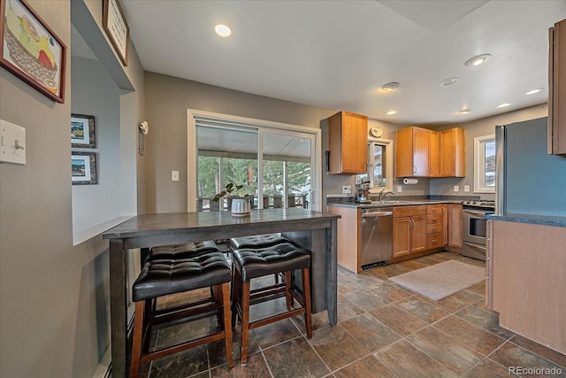 kitchen with dark tile floors, appliances with stainless steel finishes, and sink