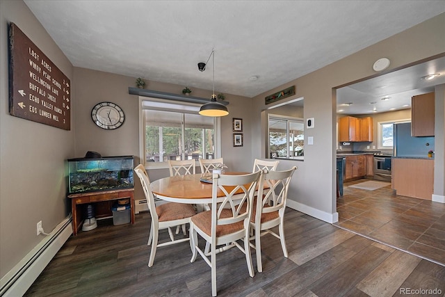 tiled dining room featuring a healthy amount of sunlight and baseboard heating