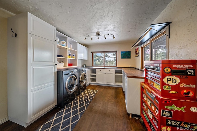 kitchen featuring rail lighting, butcher block counters, dark hardwood / wood-style floors, washer and clothes dryer, and white cabinets