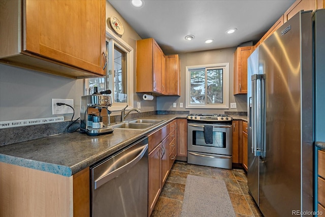 kitchen with dark tile floors, stainless steel appliances, and sink