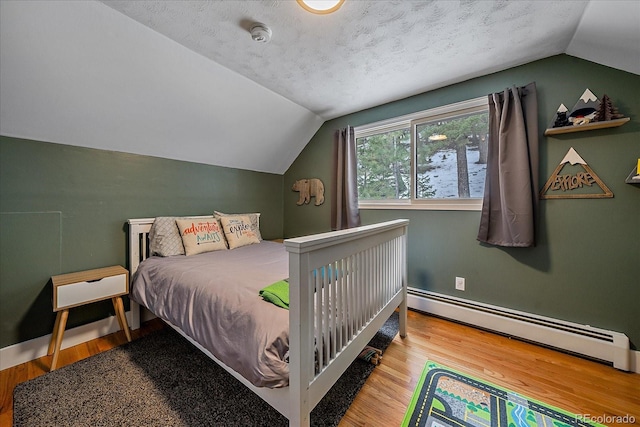 bedroom featuring hardwood / wood-style floors, lofted ceiling, a baseboard heating unit, and a textured ceiling