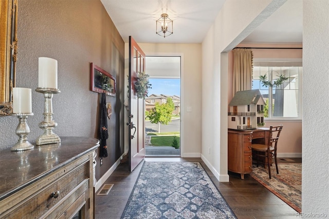 3741 Harvard Pl, Broomfield, CO 80023 - entrance foyer with dark wood-type flooring, a textured wall, and a chandelier