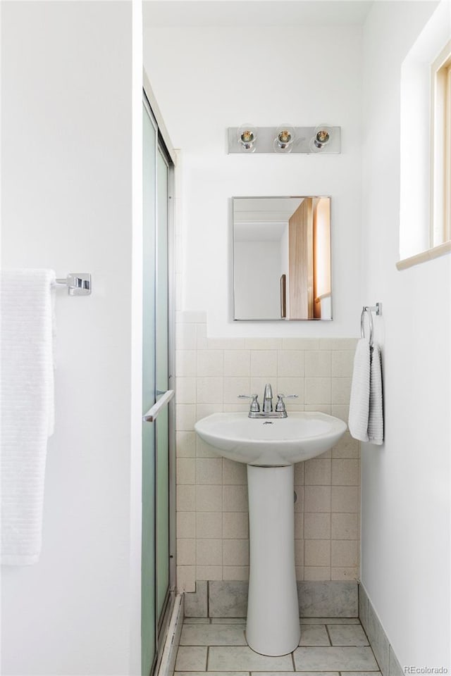 6580 Independence Way, Arvada, CO 80004 - bathroom featuring tile walls, tile patterned flooring, a stall shower, and wainscoting