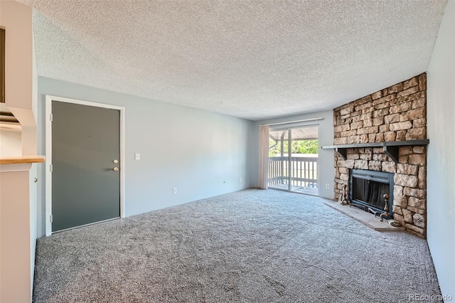 unfurnished living room with a textured ceiling, carpet floors, and a stone fireplace