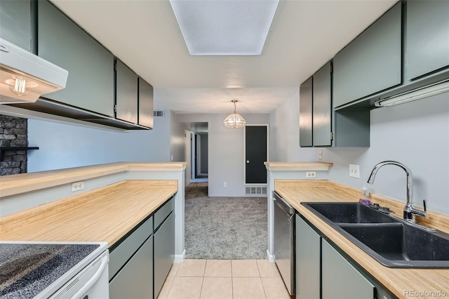 kitchen with dishwasher, sink, light tile patterned floors, and hanging light fixtures