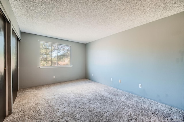 carpeted spare room with a textured ceiling