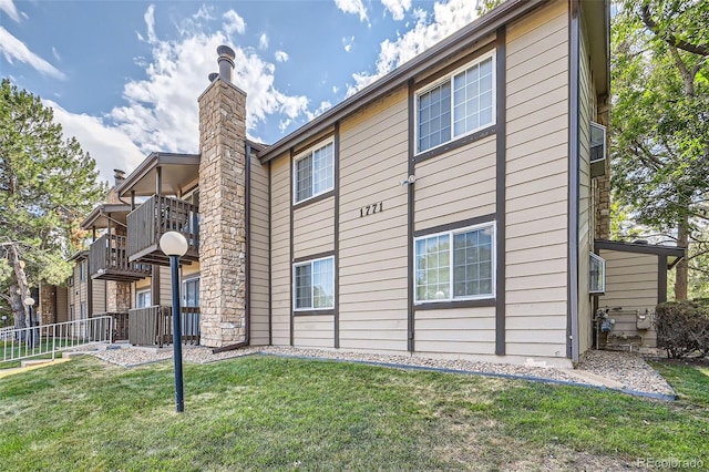 exterior space featuring a balcony and a lawn