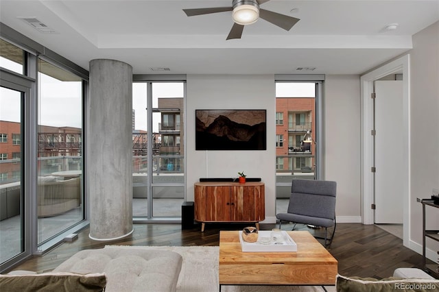 living area featuring visible vents, expansive windows, baseboards, and hardwood / wood-style flooring