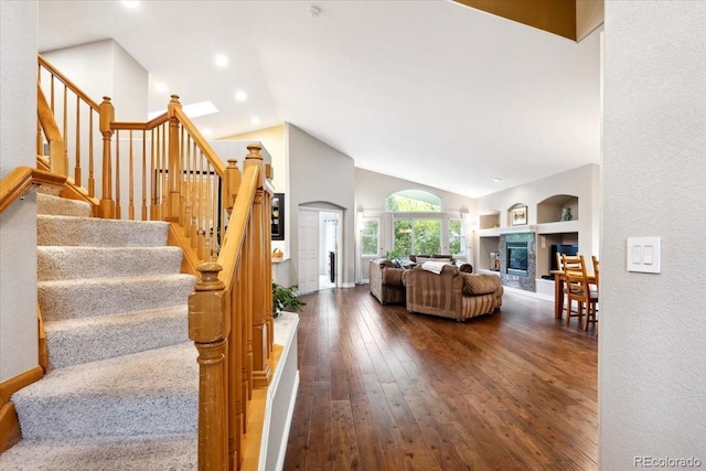 19113 W 60th Ln, Golden, CO 80403 - stairs featuring vaulted ceiling, hardwood / wood-style flooring, a glass covered fireplace, and built in features
