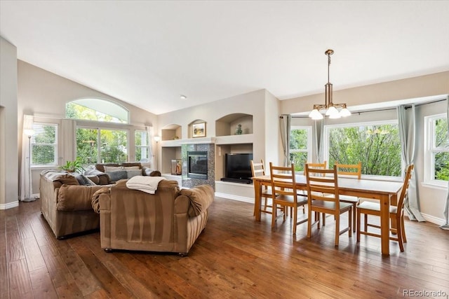 19113 W 60th Ln, Golden, CO 80403 - living room featuring dark wood-type flooring, a chandelier, built in features, a fireplace, and vaulted ceiling