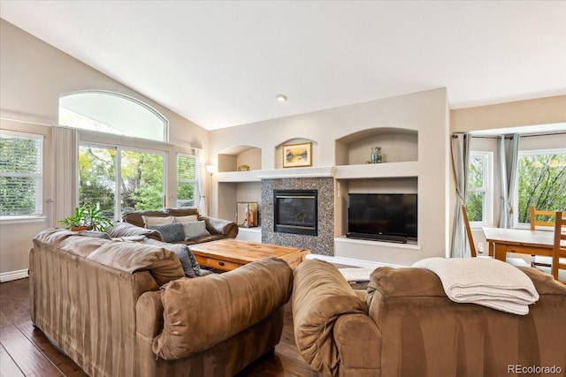 19113 W 60th Ln, Golden, CO 80403 - living area with built in features, lofted ceiling, dark wood-style floors, and a tiled fireplace