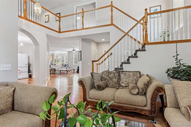 17391 E Weaver Ave, Aurora, CO 80016 - living area with a towering ceiling, wood finished floors, arched walkways, stairway, and ceiling fan