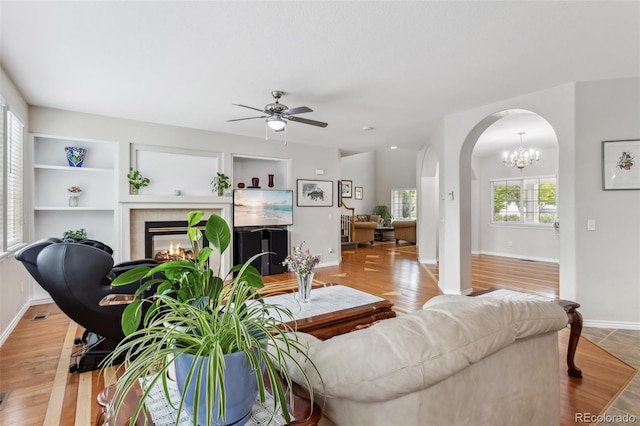 17391 E Weaver Ave, Aurora, CO 80016 - living area with arched walkways, a fireplace, ceiling fan, and baseboards