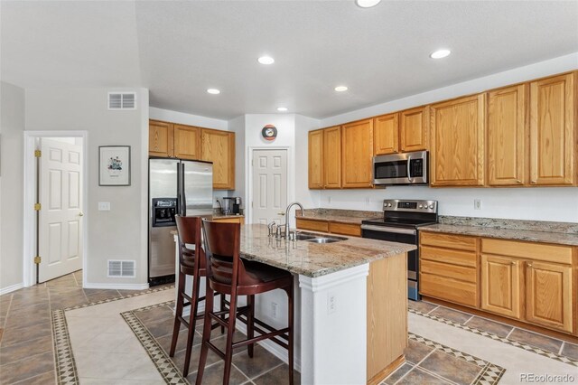 17391 E Weaver Ave, Aurora, CO 80016 - kitchen featuring appliances with stainless steel finishes, a sink, recessed lighting, tile patterned floors, and light stone counters
