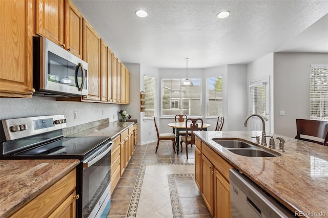 17391 E Weaver Ave, Aurora, CO 80016 - kitchen featuring appliances with stainless steel finishes, a sink, baseboards, light stone countertops, and a textured ceiling
