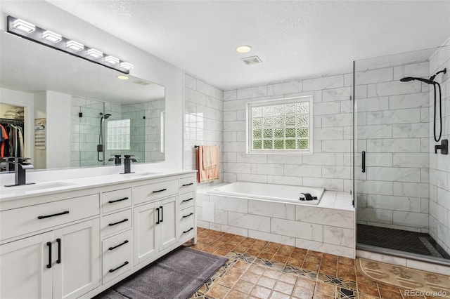 17391 E Weaver Ave, Aurora, CO 80016 - full bathroom featuring a shower stall, a garden tub, double vanity, recessed lighting, and a textured ceiling