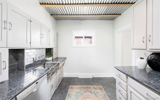 kitchen featuring stainless steel dishwasher, backsplash, baseboards, and white cabinets