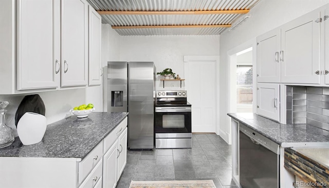 kitchen with dark stone counters, white cabinetry, appliances with stainless steel finishes, and tasteful backsplash