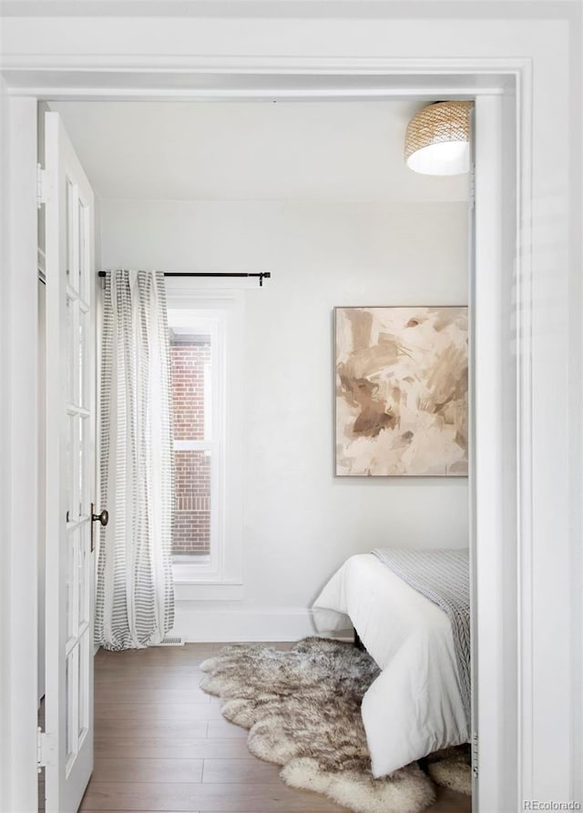 bedroom featuring baseboards and wood finished floors