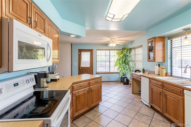750 S Dearborn Ct, Aurora, CO 80012 - kitchen featuring white appliances, light tile patterned floors, a ceiling fan, brown cabinetry, and a peninsula