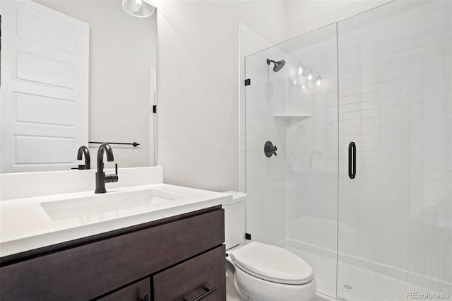 bathroom featuring toilet, vanity, and an enclosed shower