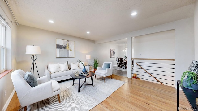 living room featuring light hardwood / wood-style flooring and a textured ceiling