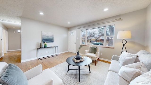 living room featuring a textured ceiling and light wood-type flooring