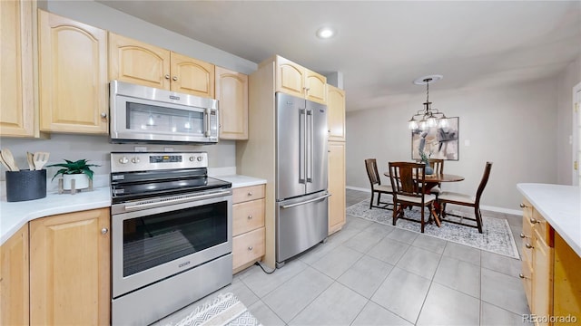 kitchen with an inviting chandelier, light tile patterned floors, light brown cabinets, pendant lighting, and stainless steel appliances