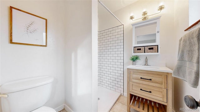 bathroom with toilet, vanity, tile patterned floors, and walk in shower