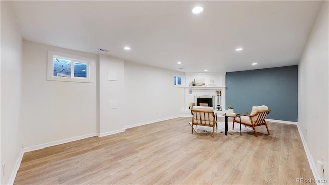 living area featuring a fireplace and light hardwood / wood-style flooring