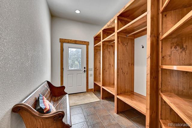 15947 Huckleberry Hts, Colorado Springs, CO 80908 - mudroom featuring stone finish flooring and a textured wall