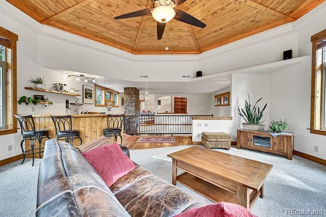 15947 Huckleberry Hts, Colorado Springs, CO 80908 - carpeted living room with baseboards, ceiling fan, visible vents, and wooden ceiling