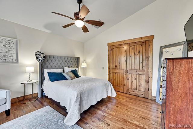 15947 Huckleberry Hts, Colorado Springs, CO 80908 - bedroom with wood finished floors, a ceiling fan, baseboards, and lofted ceiling