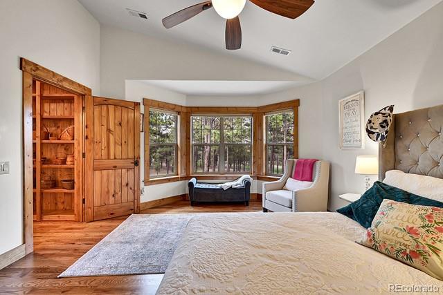 15947 Huckleberry Hts, Colorado Springs, CO 80908 - bedroom featuring visible vents, a ceiling fan, wood finished floors, and vaulted ceiling