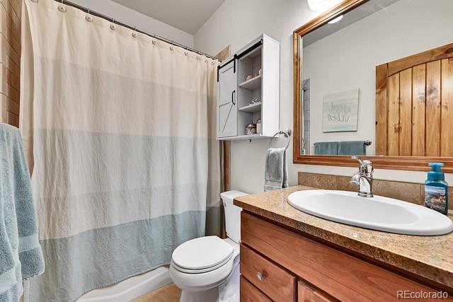 15947 Huckleberry Hts, Colorado Springs, CO 80908 - bathroom with vanity, toilet, and a shower with curtain