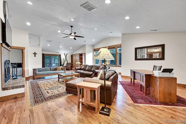 15947 Huckleberry Hts, Colorado Springs, CO 80908 - living room featuring ceiling fan, light wood-style flooring, recessed lighting, lofted ceiling, and visible vents