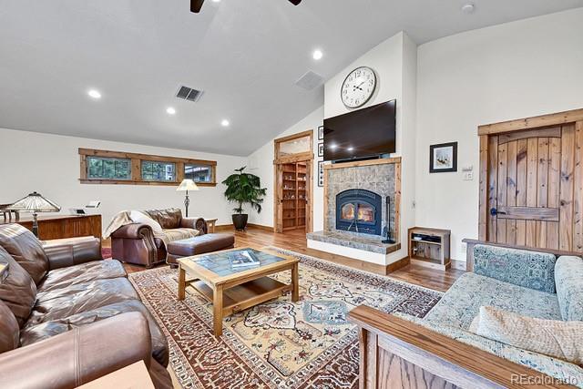 15947 Huckleberry Hts, Colorado Springs, CO 80908 - living area with a ceiling fan, recessed lighting, wood finished floors, a tile fireplace, and visible vents