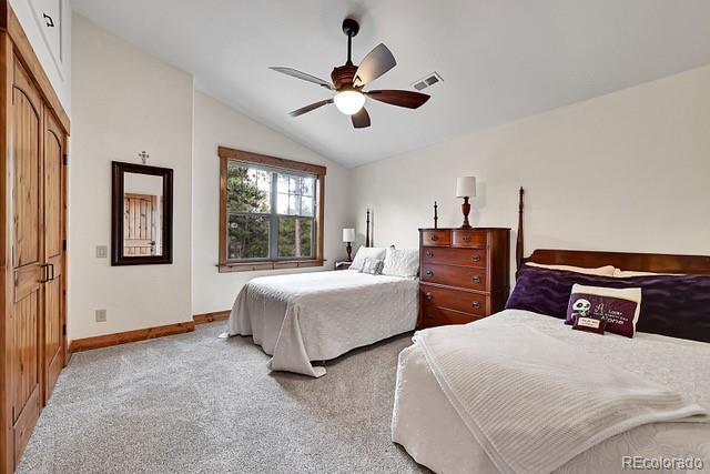 15947 Huckleberry Hts, Colorado Springs, CO 80908 - bedroom with a ceiling fan, visible vents, carpet floors, baseboards, and lofted ceiling